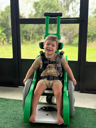 Boy uses green Toddler Mobility Trainer